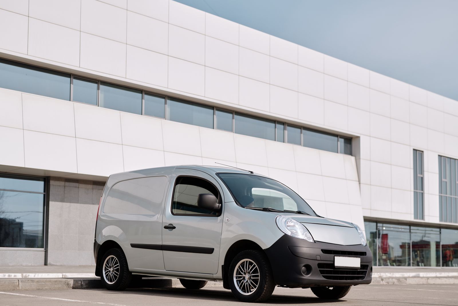 White work van parked outside an office building